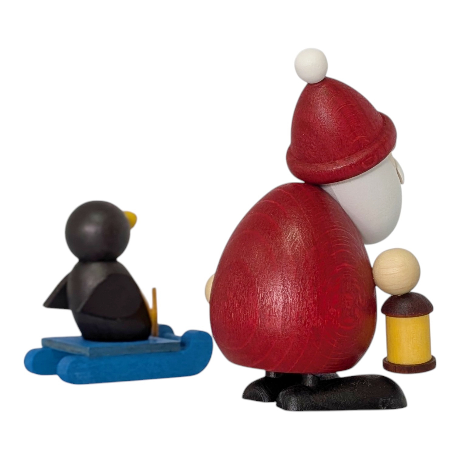 Weihnachtsmann mit Schlitten und Pinguin